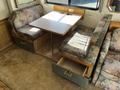 A 2000 Ford Motorhome features a cozy interior with a table and upholstered seating arrangements in floral patterns with storage drawers below the benches