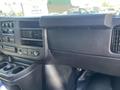 Interior dashboard of a 2012 Chevrolet Express featuring controls for the audio system and air conditioning along with cup holders and a storage compartment
