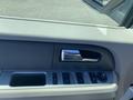 Interior view of a 2013 Ford Expedition door panel featuring window controls and a chrome door handle