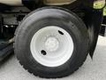 Close-up of a large wheel and tire of a 2012 Autocar Xpert featuring a robust tread pattern and a multi-spoke white rim