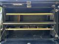 The image shows the open storage compartment of a 2008 Ford F-550 with metal shelves and dividers inside