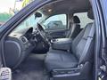A 2011 Chevrolet Avalanche with black interior seating featuring a driver's seat and passenger seat with a center console between them