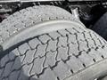 Close-up of worn tires on a 2012 Volvo VNL showing distinct tread patterns and deep grooves designed for traction
