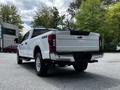 2020 Ford F-350 Super Duty in white with a four-wheel drive badge displayed on the rear tailgate
