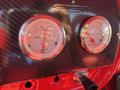 Two dials on the dashboard of a 1962 Ford F-100 showing water temperature and oil pressure with chrome trim and a textured black background