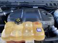 A 2017 RAM 1500 engine with a black cover and a yellow coolant reservoir featuring raised portions and a caution label