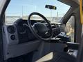 Interior view of a 2015 Ford Econoline with a steering wheel dashboard controls and a gear shift