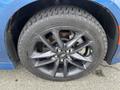 A close-up of a black alloy wheel and tire from a 2022 Dodge Charger showcasing a multi-spoke design and visible brake components