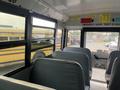 Interior view of a 2007 Freightliner B2 school bus showing rows of gray seats and windows with safety and emergency information visible