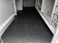 A 2013 Ford Econoline with a black diamond plate floor and empty cargo area