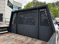 A black Ford F-350 SD truck bed with a lattice-patterned bulkhead divider and wooden flooring