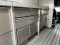 A 2006 GMC C5000 with metallic storage compartments and drawers in the interior cargo area