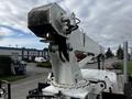 A white 2008 International 7500 truck featuring a raised utility boom with a extendable arm and bucket attachment positioned for operation