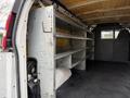 Interior view of a 2014 GMC Savana showing metal shelving units along one side of the cargo area