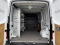 Interior of a 2017 Mercedes-Benz Sprinter van showing a spacious cargo area with metal shelving units installed on one side and a flat floor