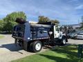 A 2007 International 7300 truck designed for waste management with a blue and white color scheme and a rear loading mechanism