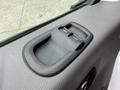 Close-up of the door panel of a 2022 Ford Transit showing a black plastic handle and two window control buttons