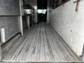 Interior view of a 2006 GMC C5000 showing a metallic striped floor and stainless steel counter surfaces on either side