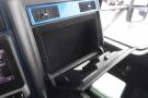 Interior view of a 2015 Kenworth T660 with a black storage compartment open showing a sleek design and functional elements