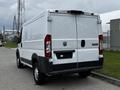 A white 2018 RAM Promaster van seen from the rear with a plain design and the RAM logo on the back door