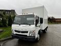 A 2012 Mitsubishi Fuso FE truck with a white box cargo area and a chrome grille visible in the foreground