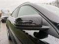Close-up of the side mirror of a 2016 Mercedes-Benz GLA-250 showing sleek design and raindrops on the surface