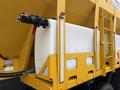 A white plastic tank mounted on a yellow framework with a black nozzle and red valve attached