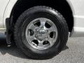 Close-up of a silver alloy wheel on a 2003 Mitsubishi Delica with a rugged tire tread design