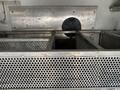A 2015 Ford F-550 truck with a metal storage compartment featuring multiple perforated bins in a grid layout
