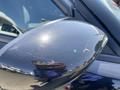 A black side mirror of a 2019 Dodge Charger with visible scratches and reflections on its surface