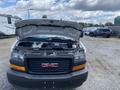 A 2023 GMC Savana with the hood raised showcasing the engine compartment