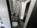 Interior of a 2022 Heartland Torque featuring a bathroom with a shower tub a sink and a toilet along with a patterned shower curtain