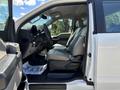 A white 2016 Ford F-150 with a spacious interior featuring gray cloth seats and a clean dashboard visible through an open driver's side door