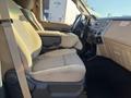 Interior view of a 2014 Ford F-350 SD showing the driver's seat and passenger seat with beige upholstery and a central console