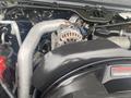 Close-up of the engine of a 2005 Ford F-350 SD featuring various mechanical components including pipes and an alternator