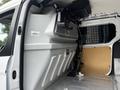 2016 Ford Transit Connect interior featuring a silver partition wall with storage compartments and a mounted tool holder