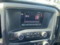 Dashboard of a 2014 GMC Sierra 1500 featuring a radio display showing a frequency of 96.9 and control buttons for radio and media settings