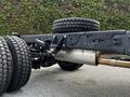 A 2024 Ford F-550 chassis showing large tires and a visible exhaust system with a focus on the rear axle and suspension components
