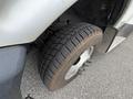 Close-up of a front tire of a 2017 Chevrolet Express showcasing a rugged tread pattern with a portion of the vehicle's body partially visible in the frame