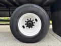 Close-up of a white wheel rim with a black Bridgestone tire mounted on a 2017 Hino 338 truck