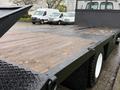 A 2008 Sterling Acterra flatbed truck with a wooden deck and black metal railing