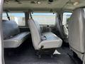 Interior of a 2004 Ford Econoline showing gray fabric seating with multiple bench seats and a clean floor area