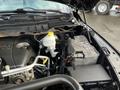 A 2015 RAM 1500 engine bay featuring the engine block battery coolant reservoir and various hoses and wires
