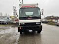 A white 2006 GMC F7B042 truck is parked facing forward with its headlights on and a large box in the back