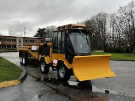 A yellow 2015 International 3000 MT6 truck with a front-mounted snow plow and a trailer attached