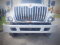 A 2016 International WorkStar 7500 truck with a shiny chrome grille and prominent front bumper showcasing its large, sturdy design