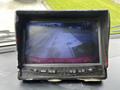 A rearview monitor displaying a view of a paved area and an empty driveway with no vehicles visible