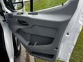 A close-up of the door panel of a 2018 Ford Transit showing the interior handle speaker grille and storage compartment