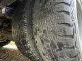 Close-up of a worn tire on a 2017 Chevrolet Express showing deep treads and dirt on the surface