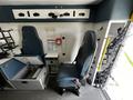 Interior view of a 2013 Chevrolet Express showing two seats and storage compartments with a seatbelt on the driver's chair